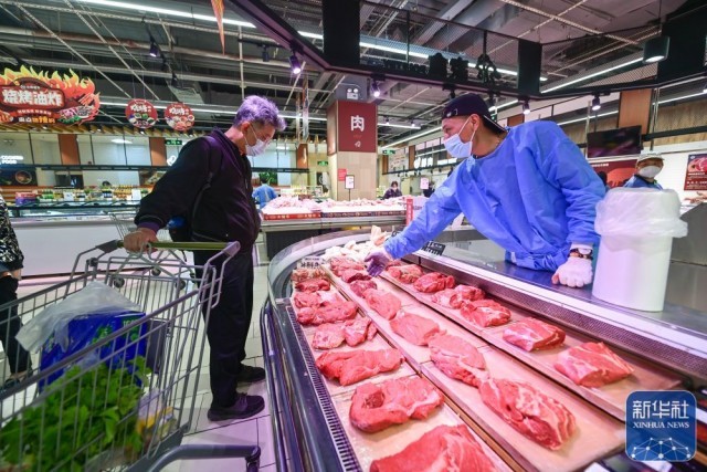 顾客在上海市松江区一家超市选购鲜肉（5月10日摄）。