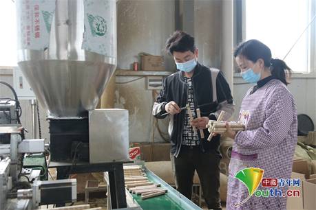 张小兵、谭亚清夫妻俩正在检验艾条产品质量。