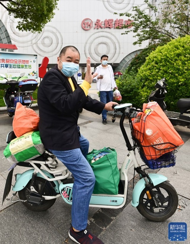 在上海市松江区一家超市外，一名顾客满载而归（5月10日摄）。
