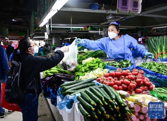 当地居民在上海市嘉定区新成路街道一家农贸市场购买新鲜蔬菜（5月9日摄）。