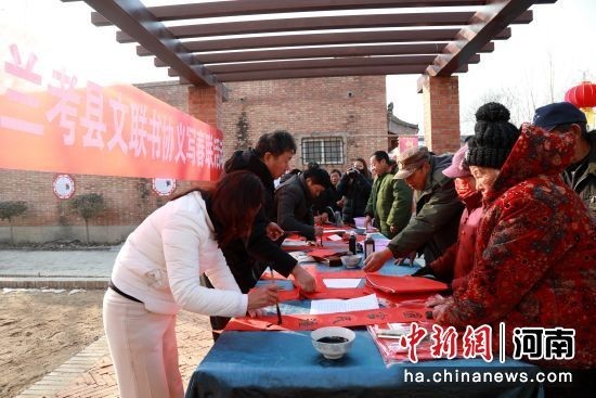 图为书法家正在为村民义写春联。 朱恒 摄