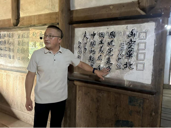 张河斌介绍墙上的红军标语（为保护原标语，现在在标语正面做了保护套，下同）。海峡网记者 李牧晨 摄